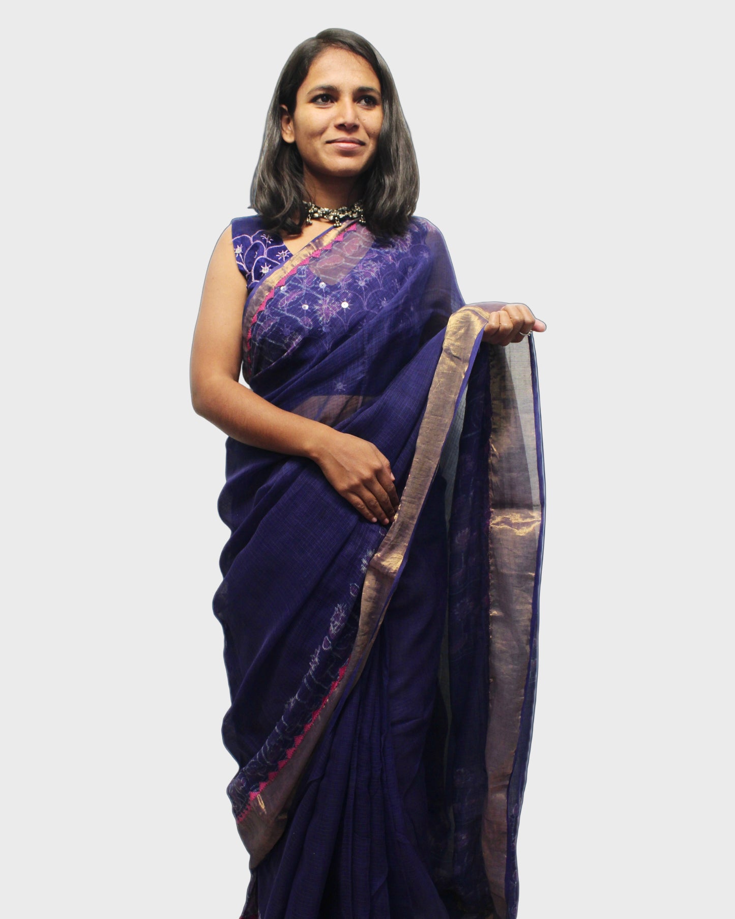A woman showcasing a purple Kota Doriya silk saree with zari and applique border.