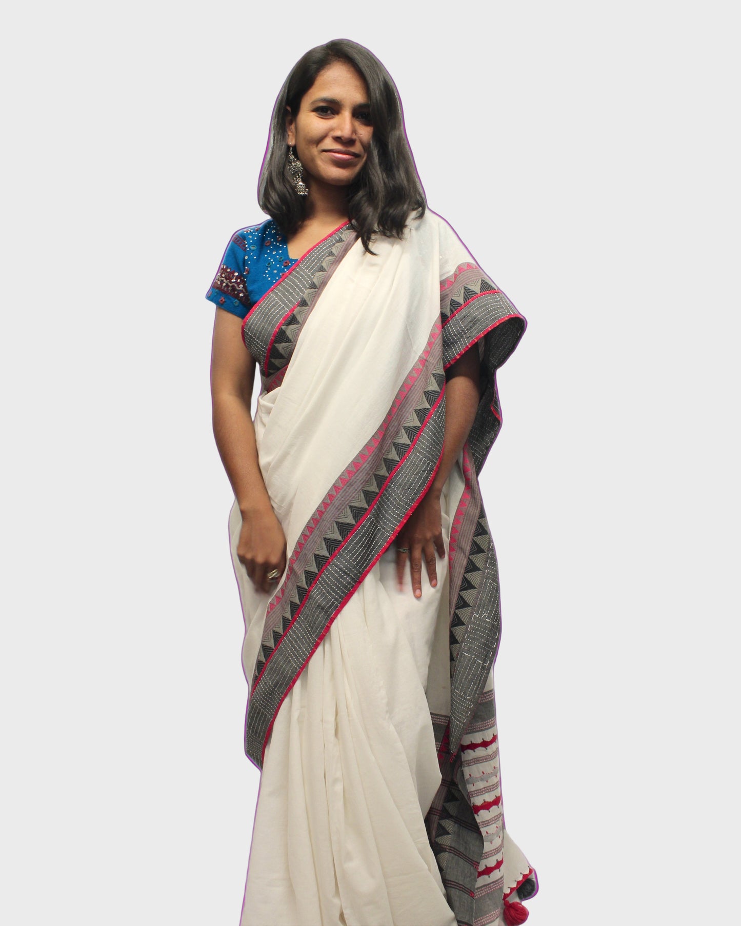 A woman showcasing a handcrafted Mangalgiri cotton saree with geometric hand embroidery and applique work, primarily in white with gray and red accents.