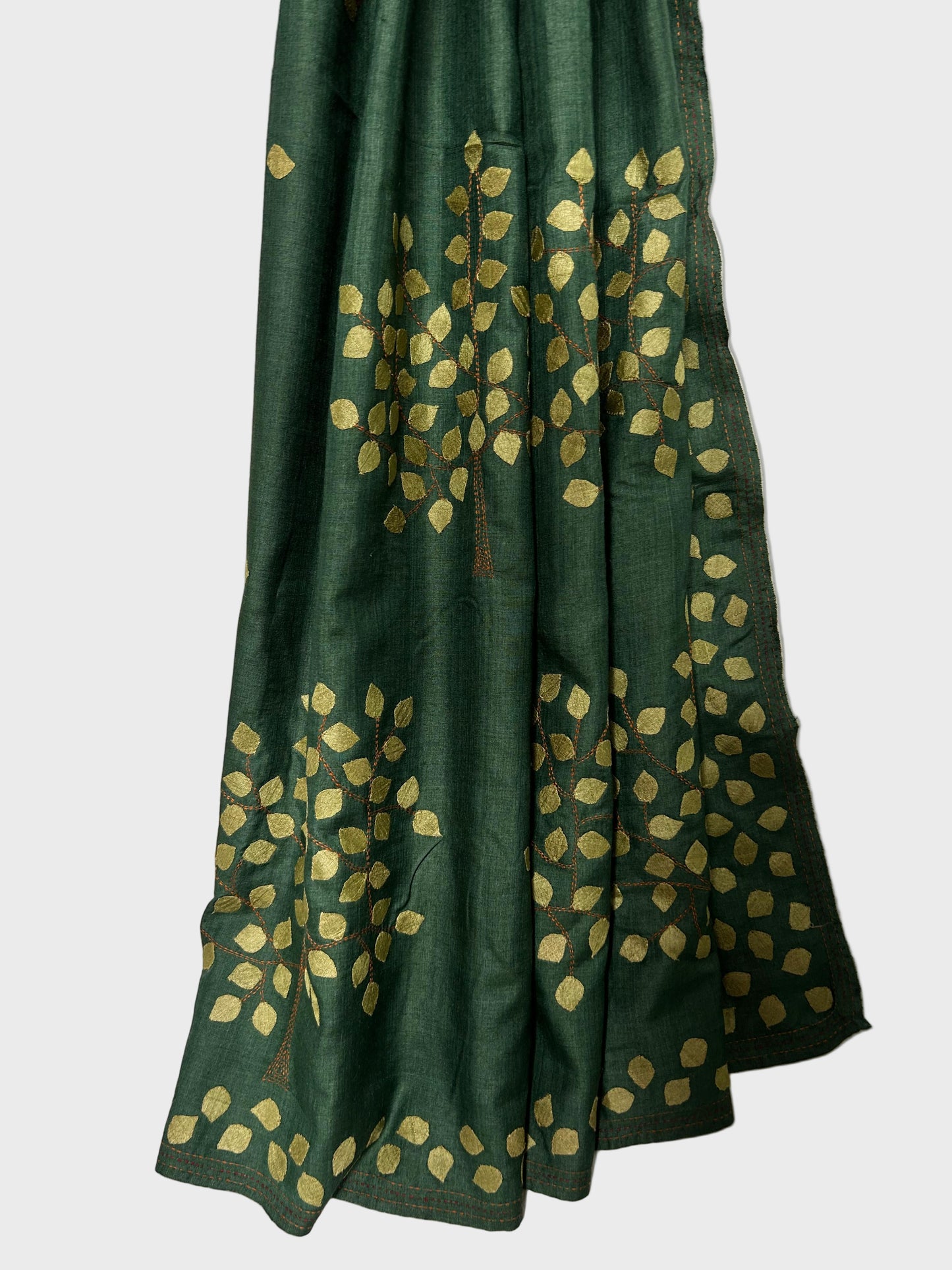 Green fabric with gold leaf patterns on a white background