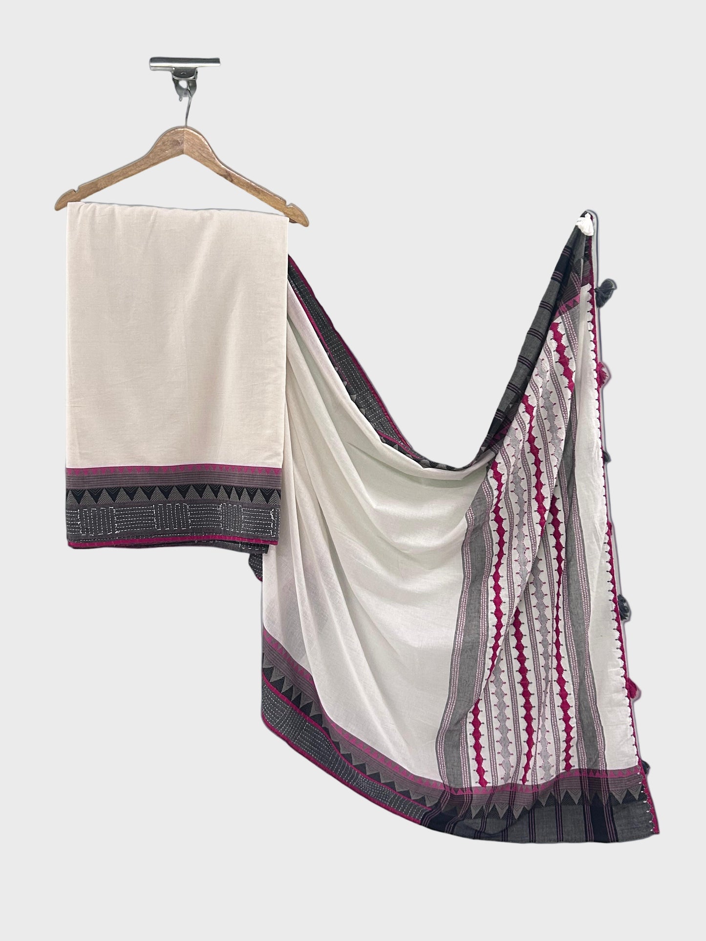 White saree with black and red border on a hanger against a light gray background