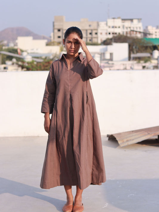 Front view of a woman wearing an earthy brown box pleat cotton Indo-Western dress with a shirt collar.