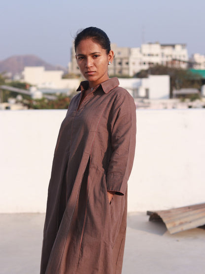 Front view of a woman wearing an earthy brown box pleat cotton Indo-Western dress with a shirt collar.