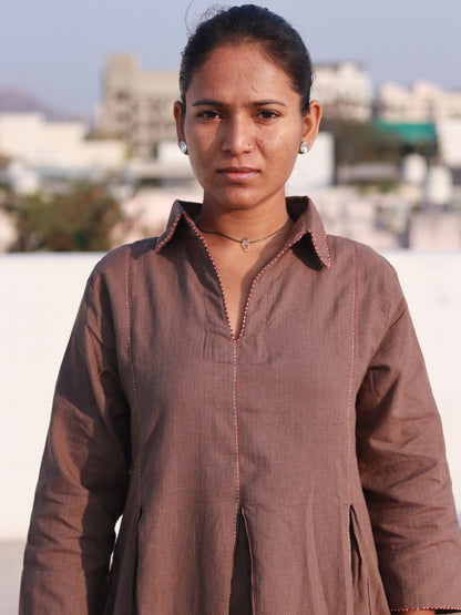 Front view of a woman wearing an earthy brown box pleat cotton Indo-Western dress with a shirt collar.