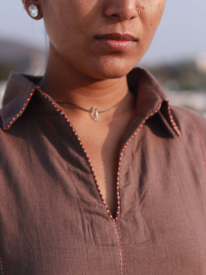 Front view of a woman wearing an earthy brown box pleat cotton Indo-Western dress with a shirt collar.