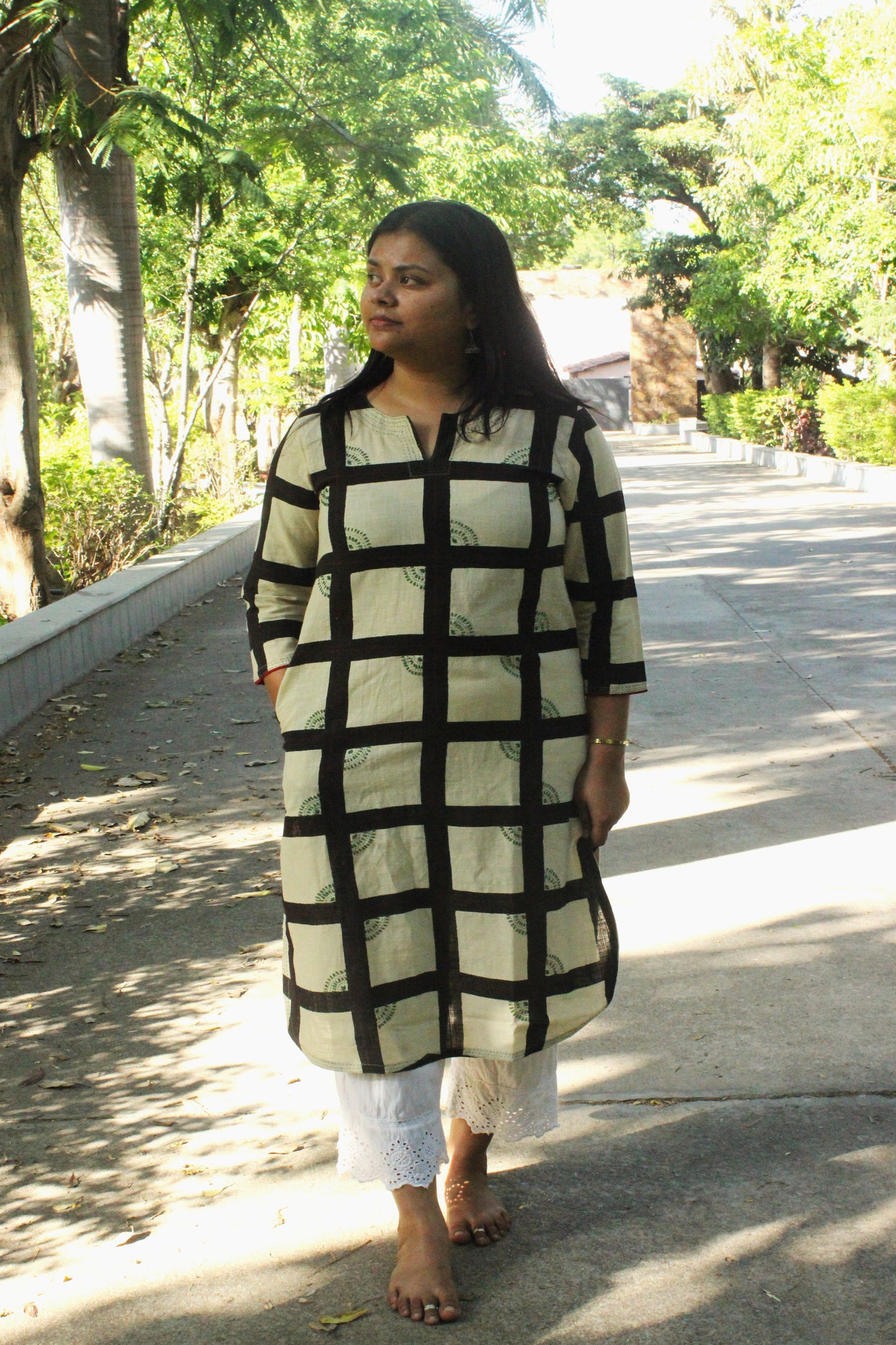 Woman wearing handcrafted off-white straight cotton kurta with checkered print and hand embroidery.