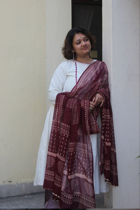 Front view of a white handcrafted appliqué cotton A-line kurta with side pockets on a model.