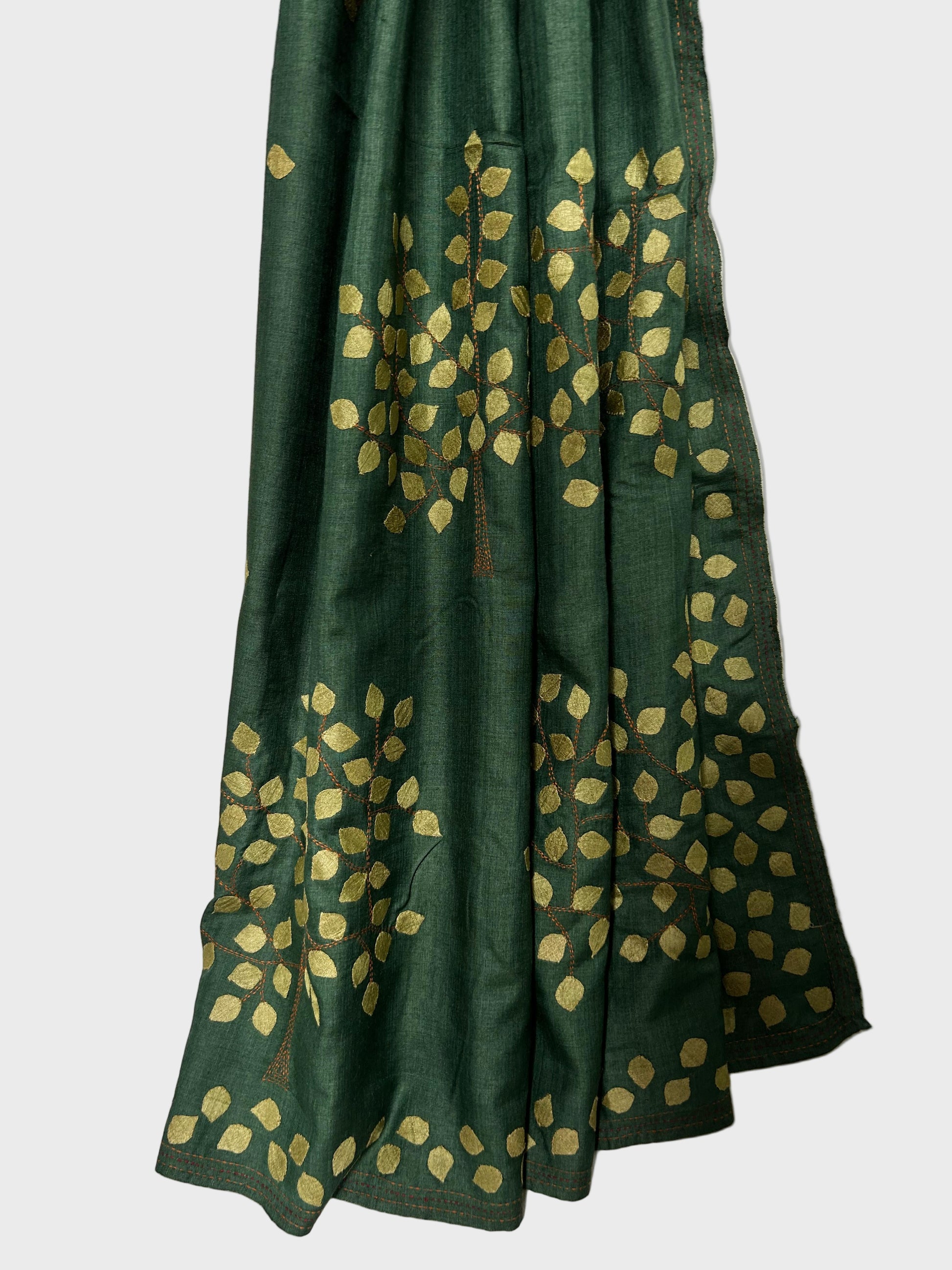 Green fabric with gold leaf patterns on a white background