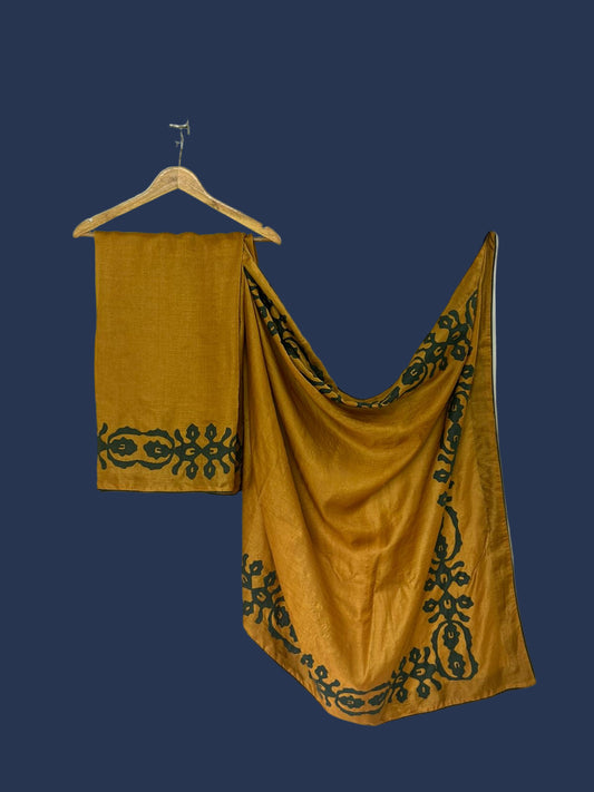 Mustard yellow fabric with black embroidery on a white background