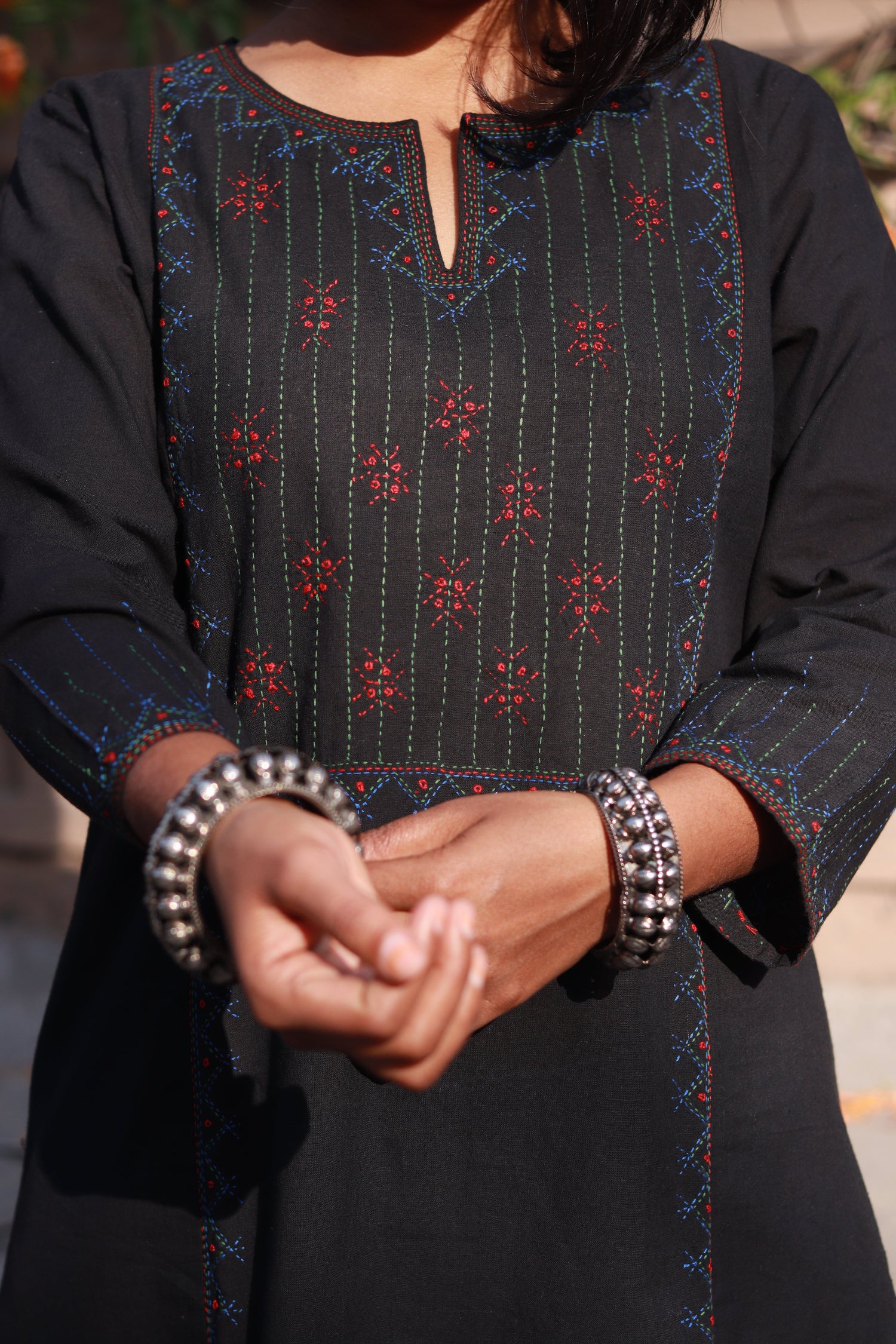 Closeup front view of a woman wearing a Tanka embroidered cotton kurta featuring traditional handmade Indian embroidery, sustainable ethnic wear with side pocket