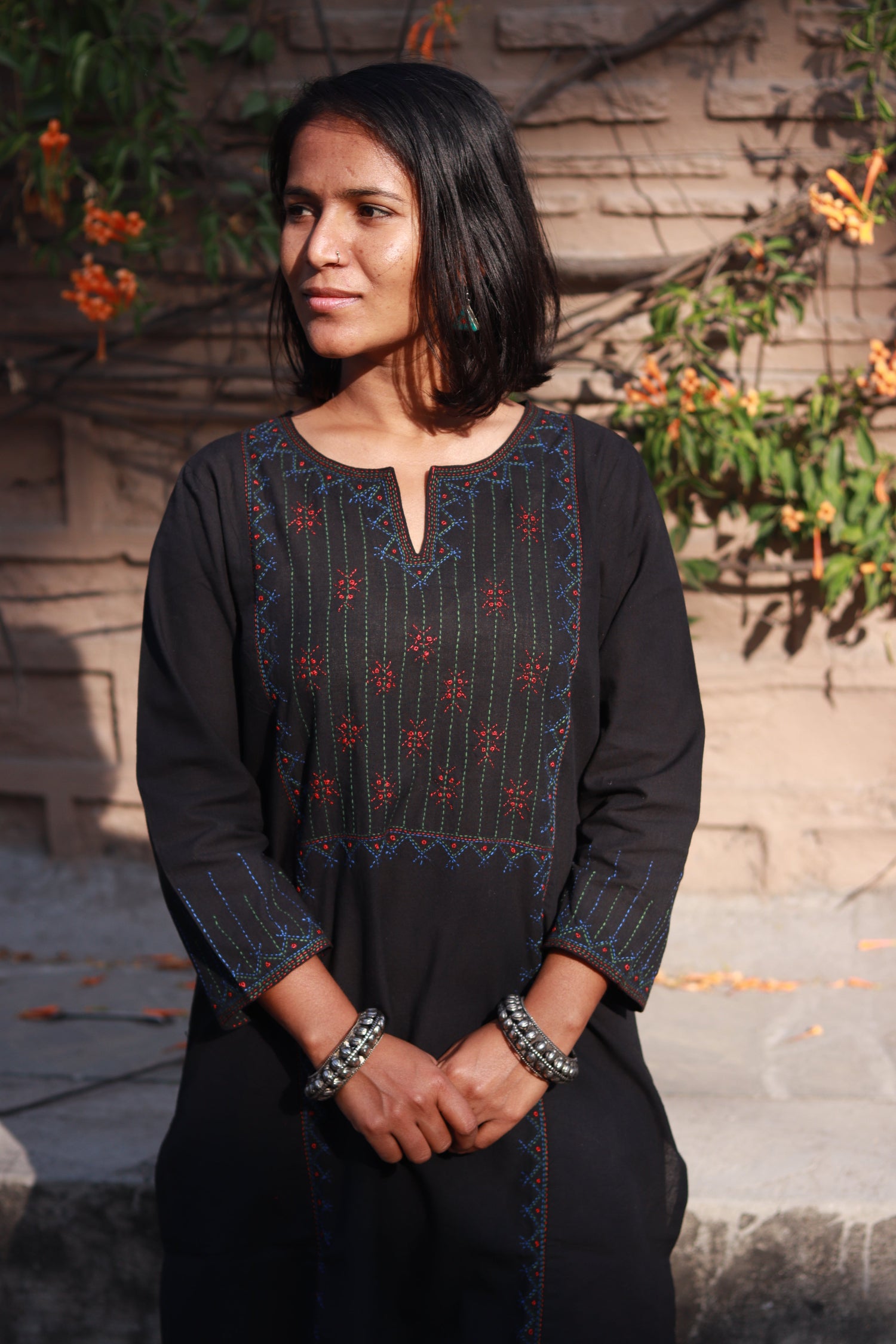 Front view of a woman wearing a Tanka embroidered cotton kurta featuring traditional handmade Indian embroidery, sustainable ethnic wear with side pocket